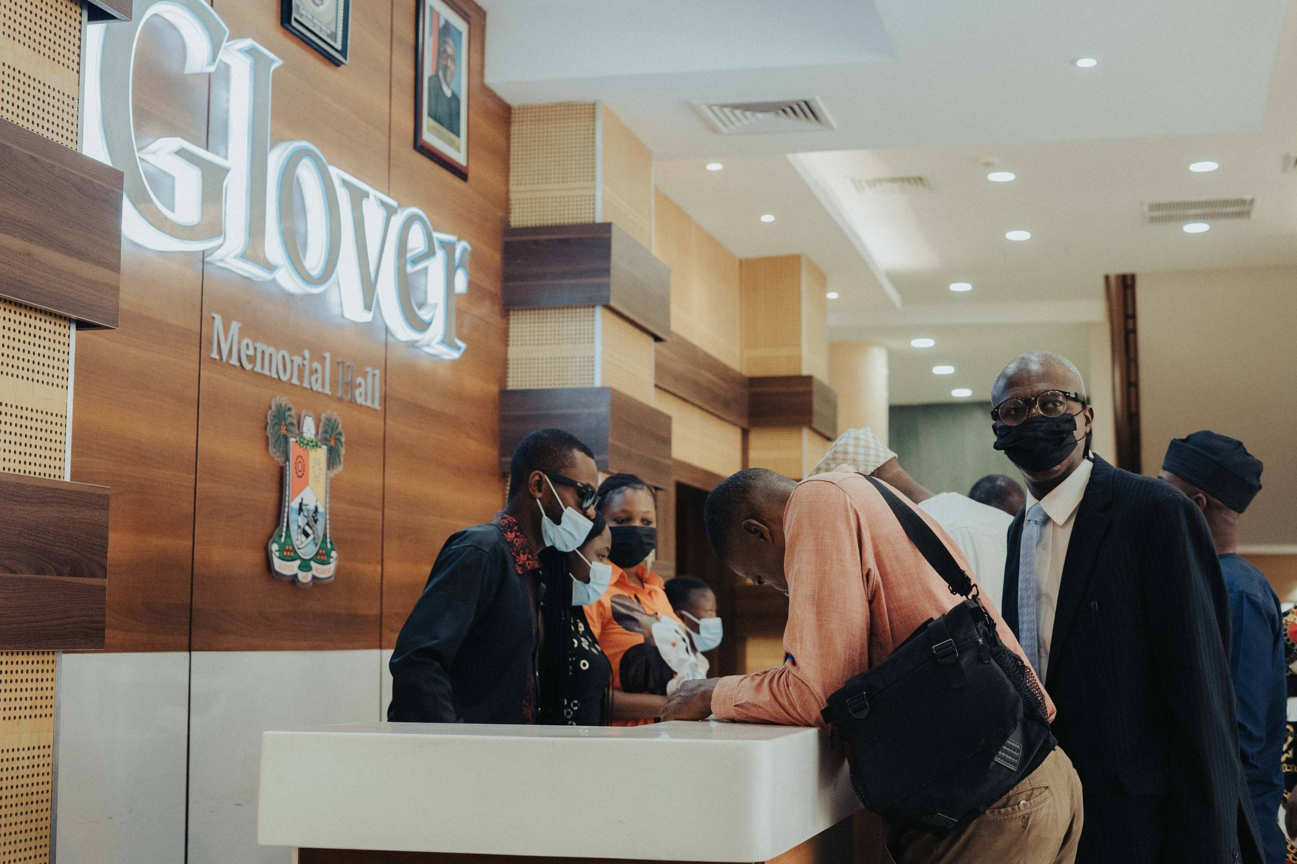 The illuminated Glover Memorial Hall lettering and Nigerian coat of arms above the reception desk in the foyer.